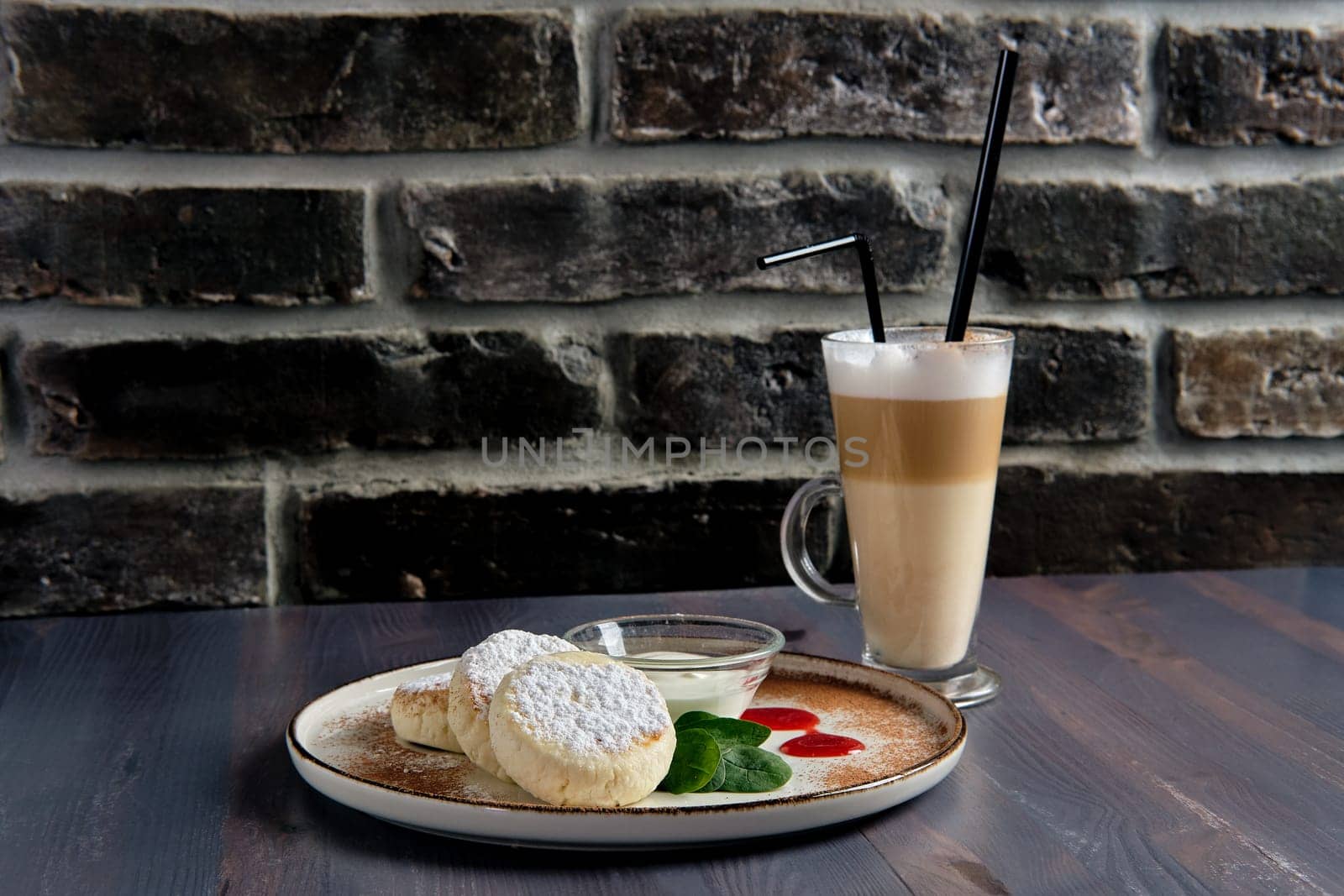 Traditional breakfast with cottage cheese pancake with sour cream, juice and latte