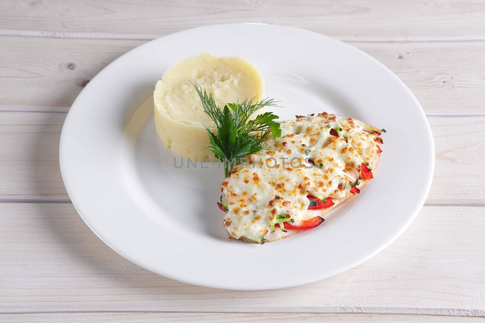 Fried chicken fillet with bell pepper, zucchini, melted cheese and mashed potato