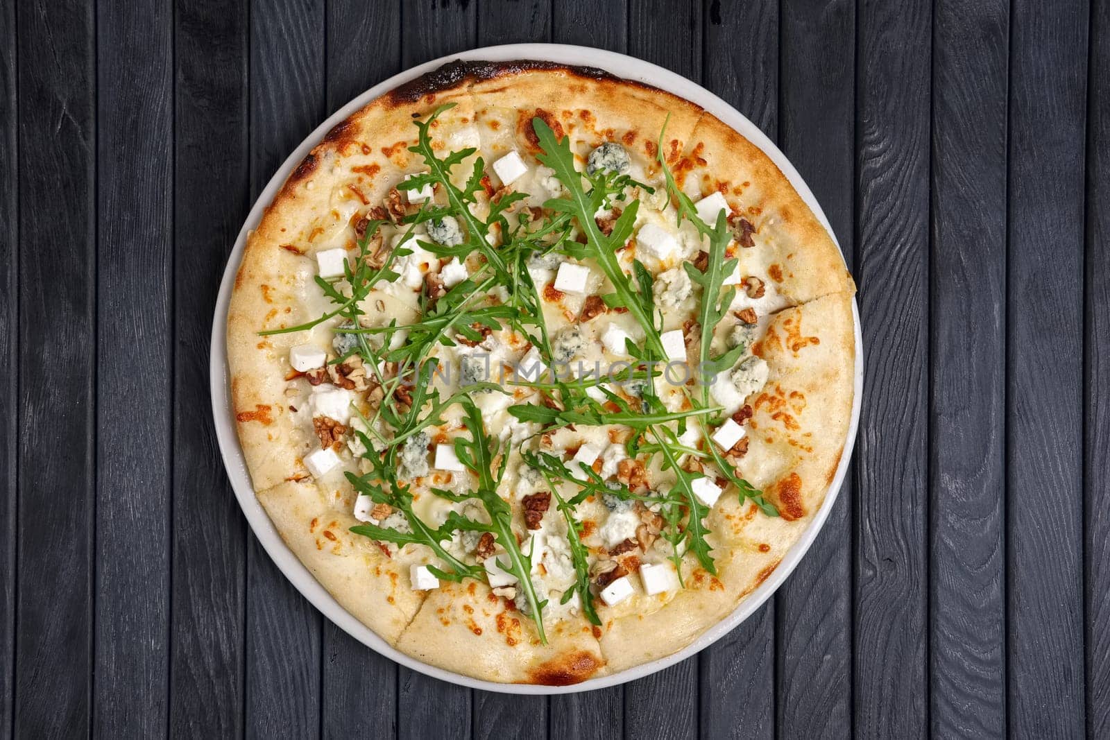 Top view of pizza with different kind of cheese with arugula