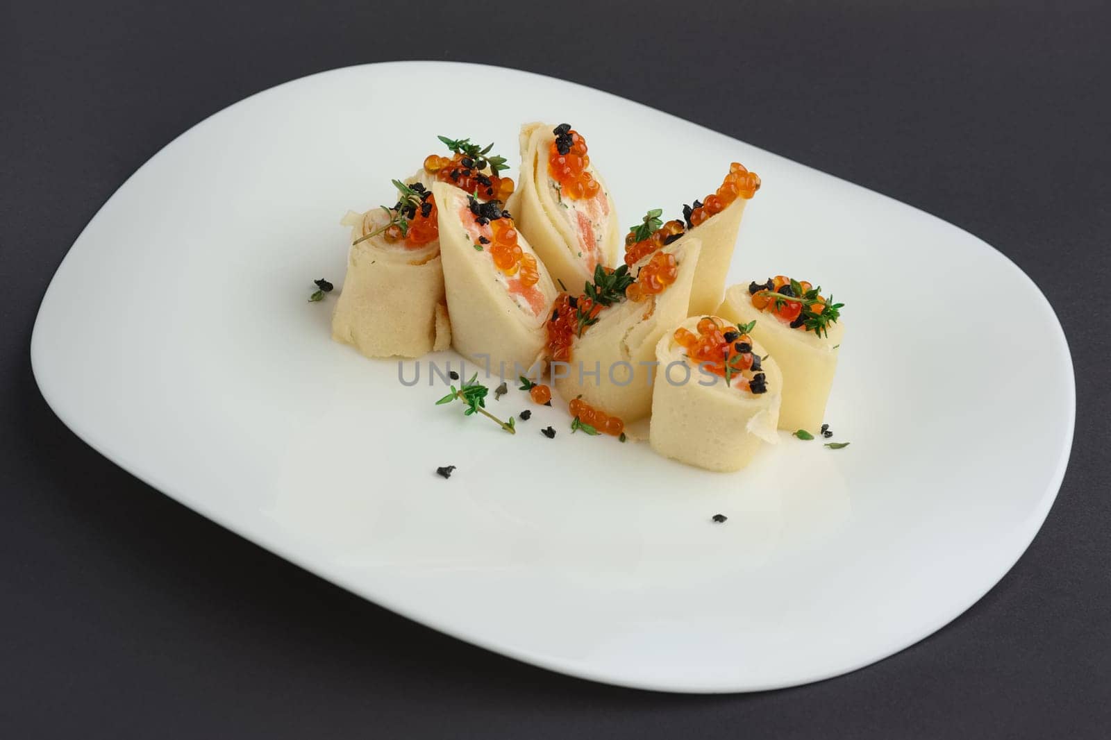 pancakes with salmon and caviar on big white plate