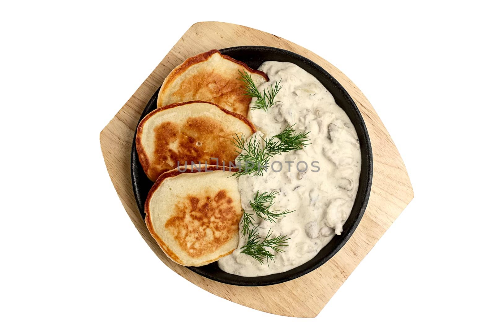 Flapjack with mushroom sauce on wooden plate. Top view.