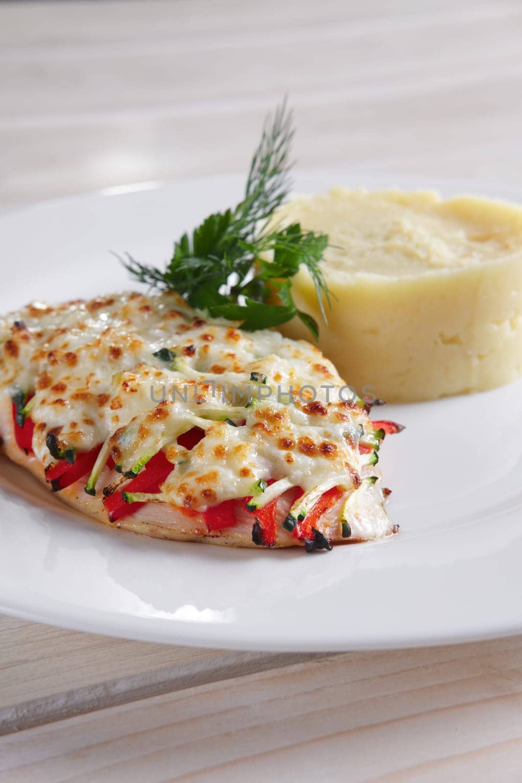 Fried chicken fillet with bell pepper, zucchini, melted cheese and mashed potato