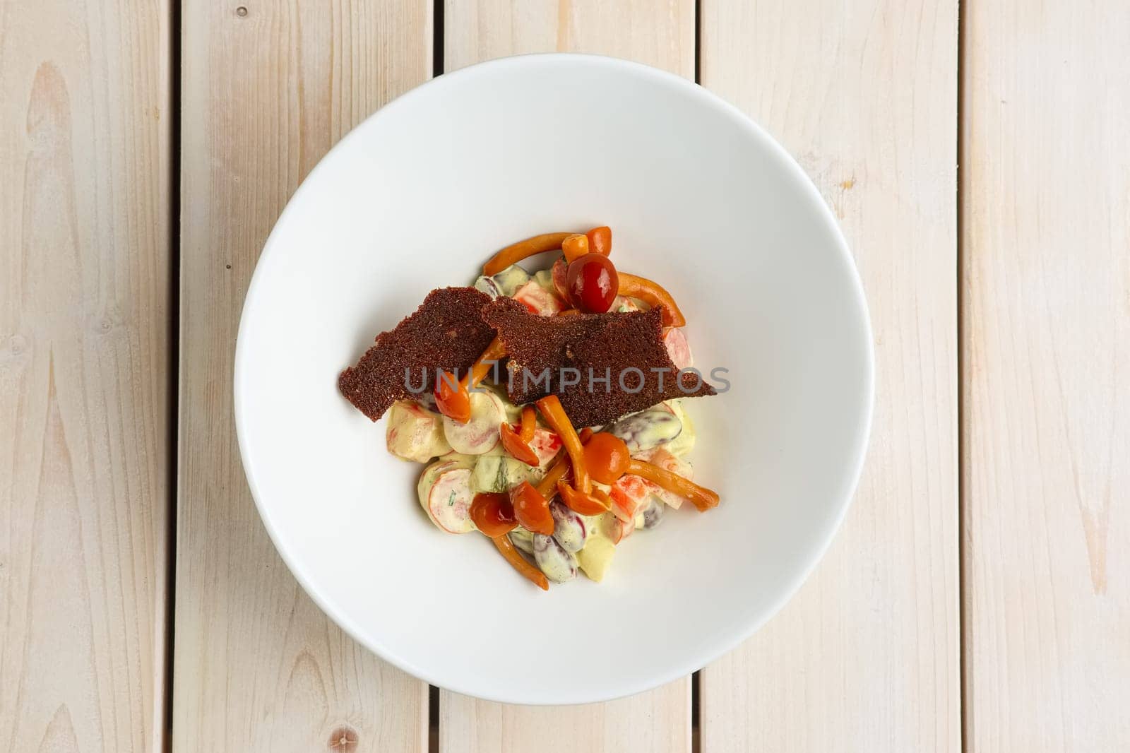 Salad with kidney beans, honey agaric, and brown bread chips