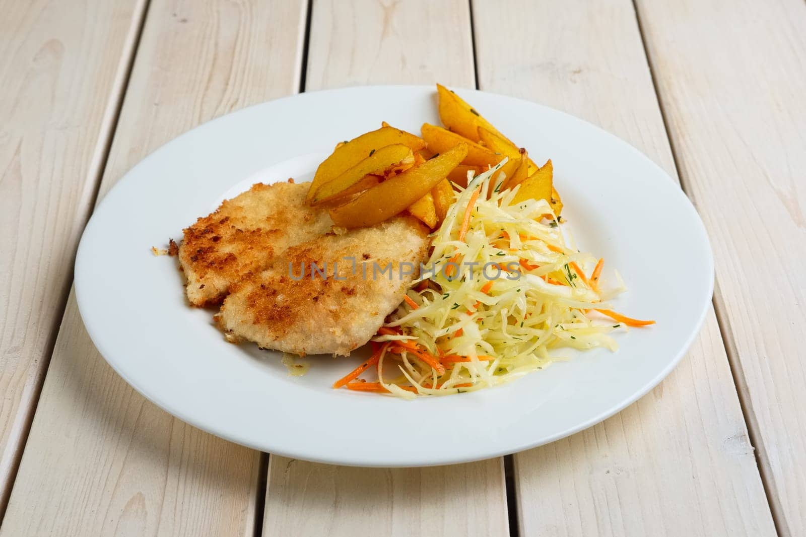 Chop cutlet with fried potato and fresh cabbage and carrot