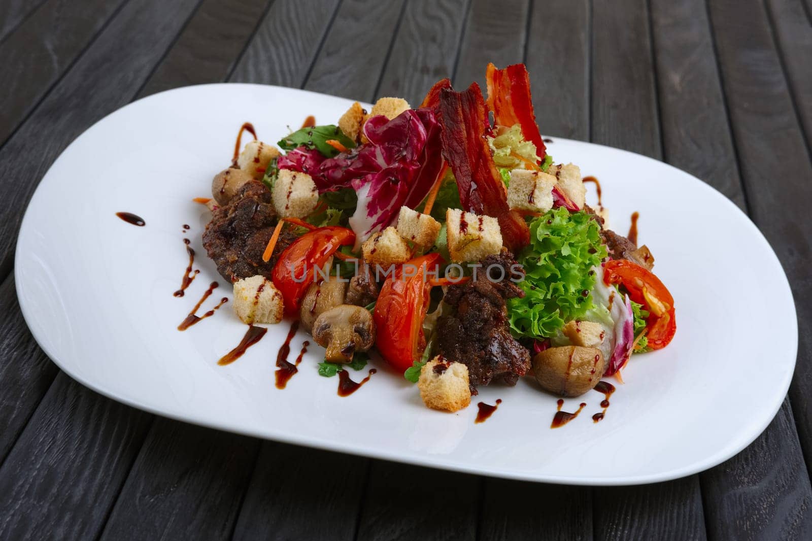 Salad with liver, bacon, grilled tomato and pepper with red cabbage and mushrooms