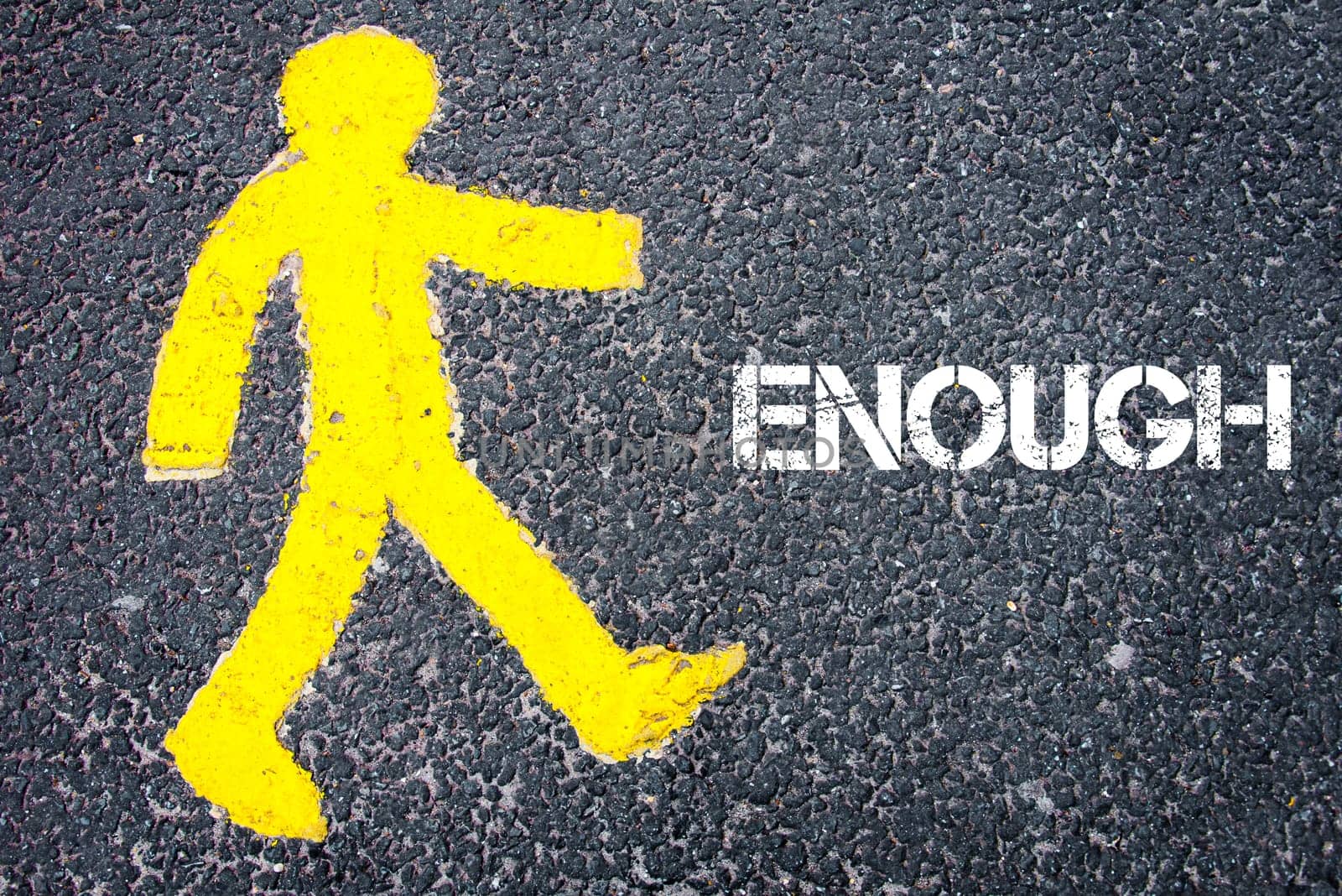Yellow pedestrian figure on the road walking towards ENOUGH. Conceptual image with Text message over asphalt background.