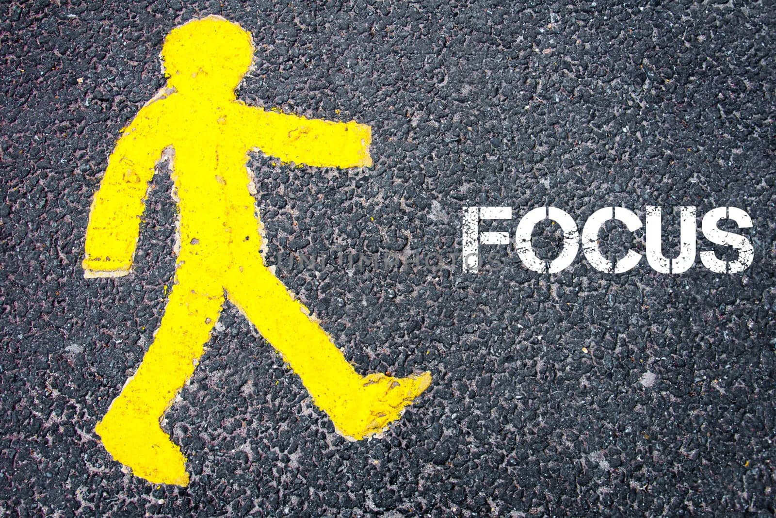 Yellow pedestrian figure on the road walking towards FOCUS. Conceptual image with Text message over asphalt background.
