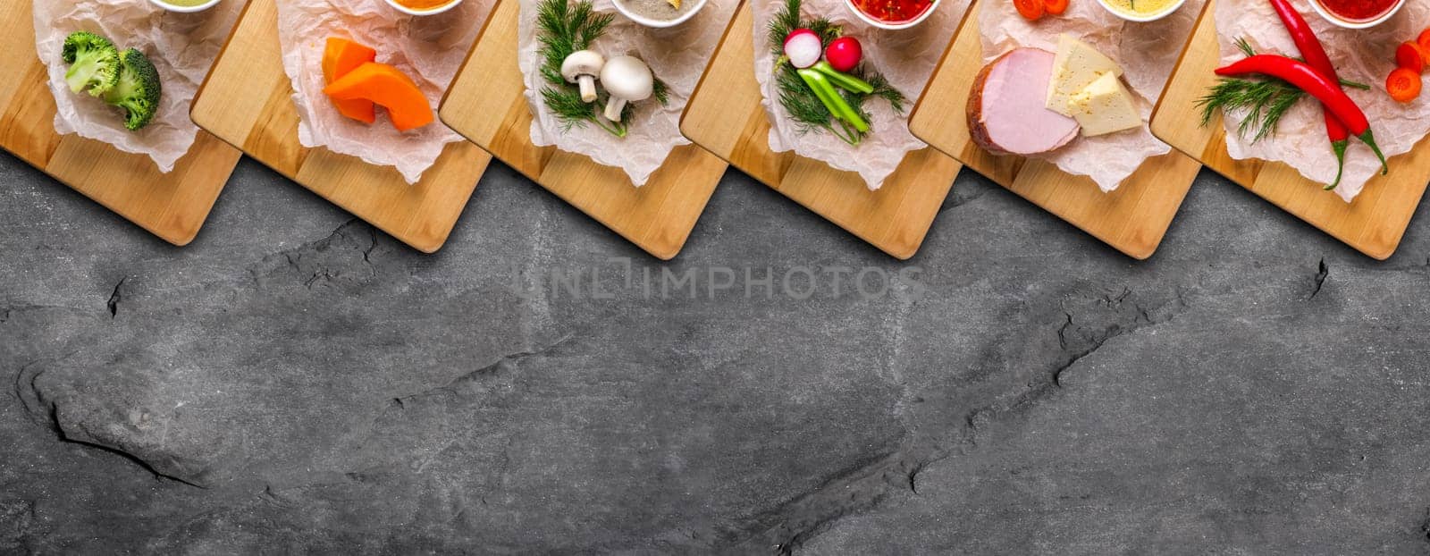 Variety of colorful vegetables and ingredients for cream soups top view on stone background