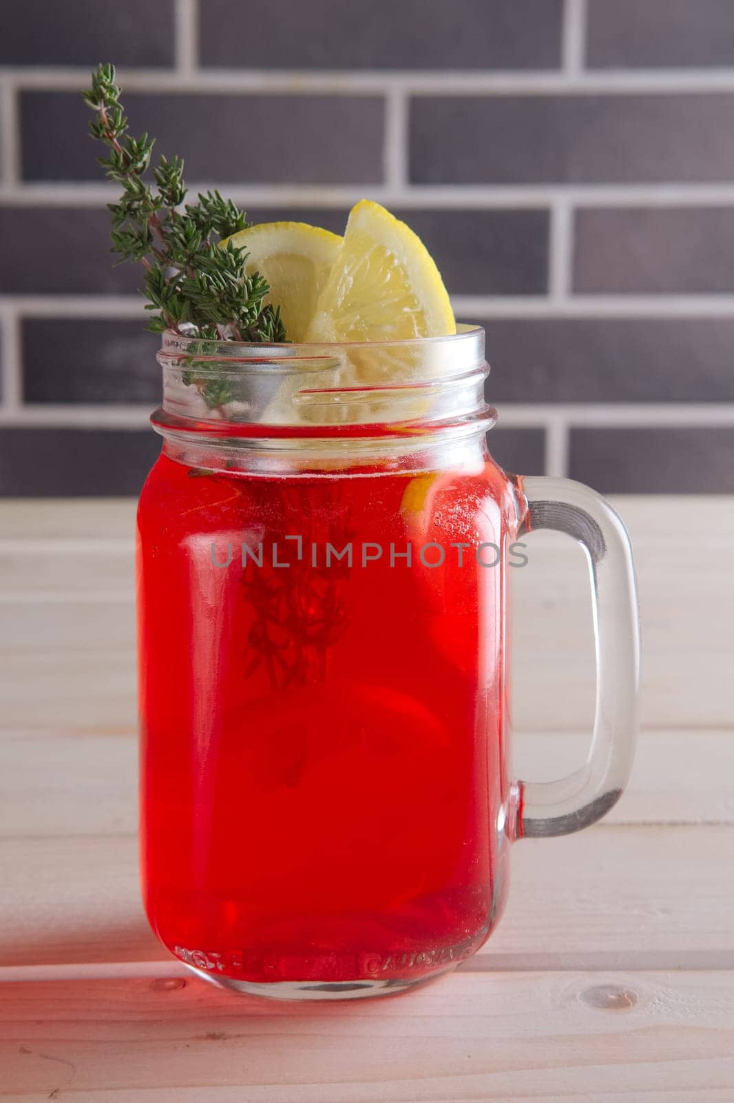 Cup of cranberry juice with citrus and rosemary