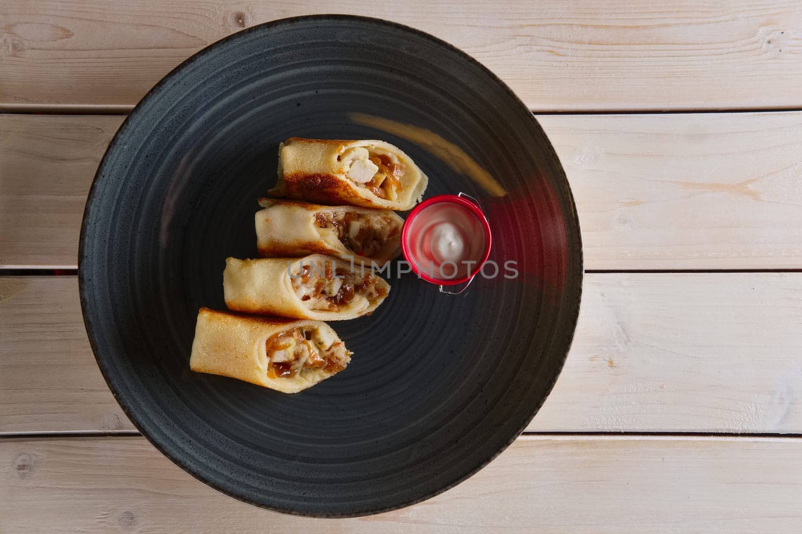 Thin pancakes with ham, bacon and barbecue sauce