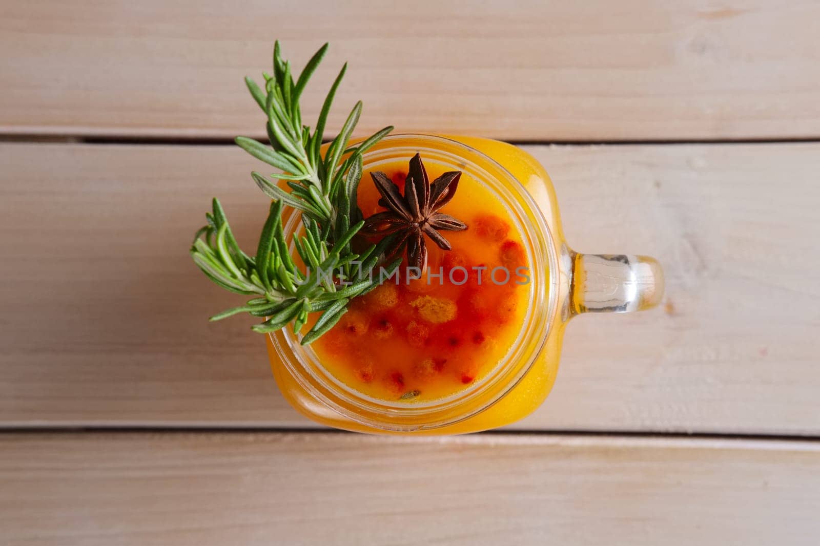 Cup of sea buckthorn tea with citrus, cinnamon and rosemary