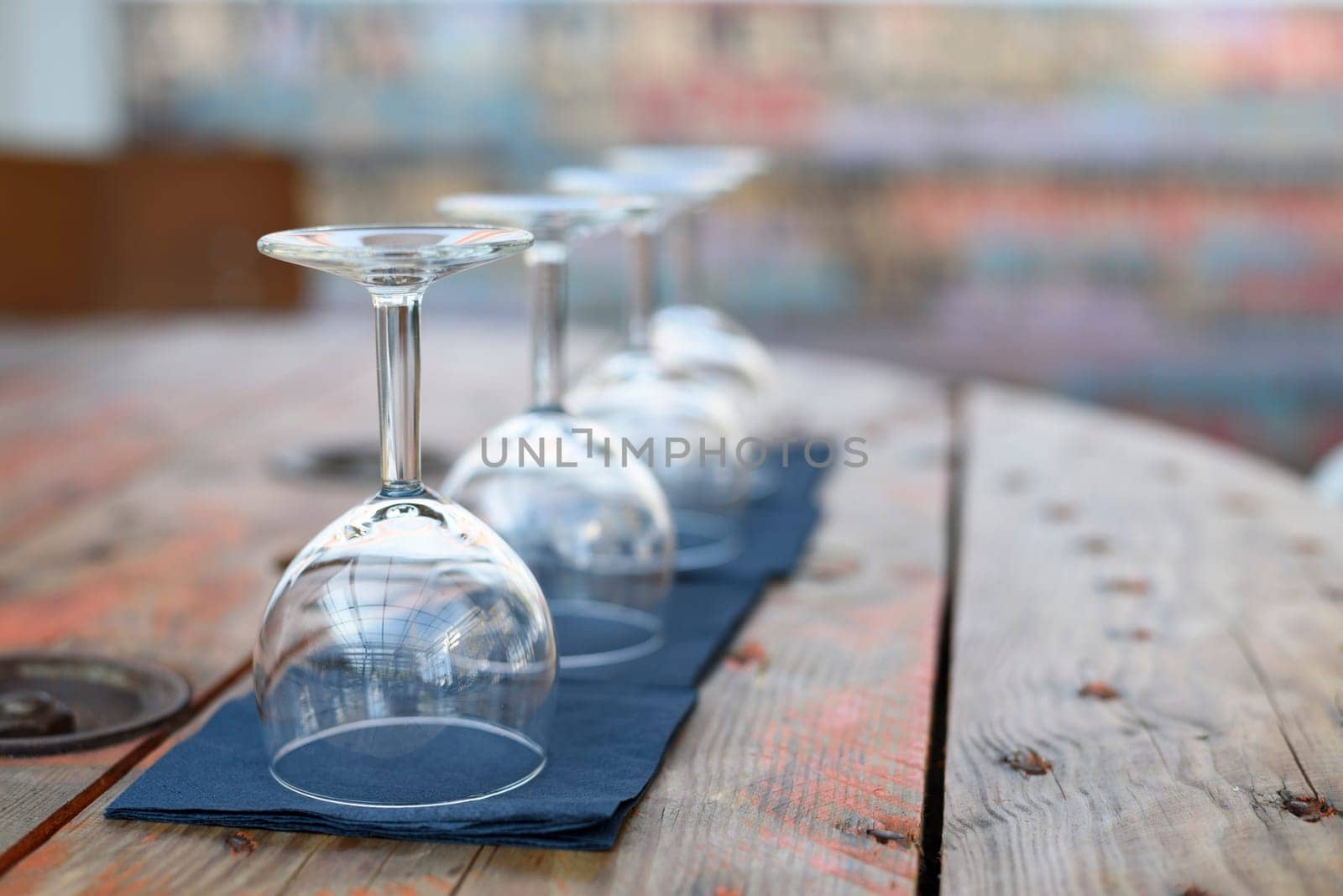 Empty wine glasses on rustic wooden table in retro restaurant interior.