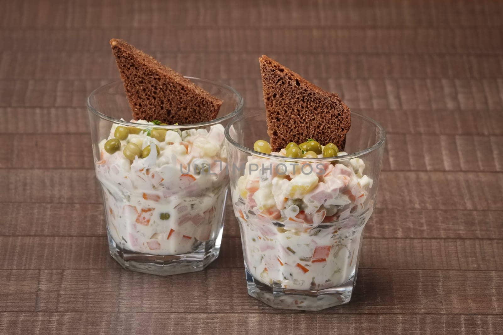 Russian traditional salad olivier with pea in glass.