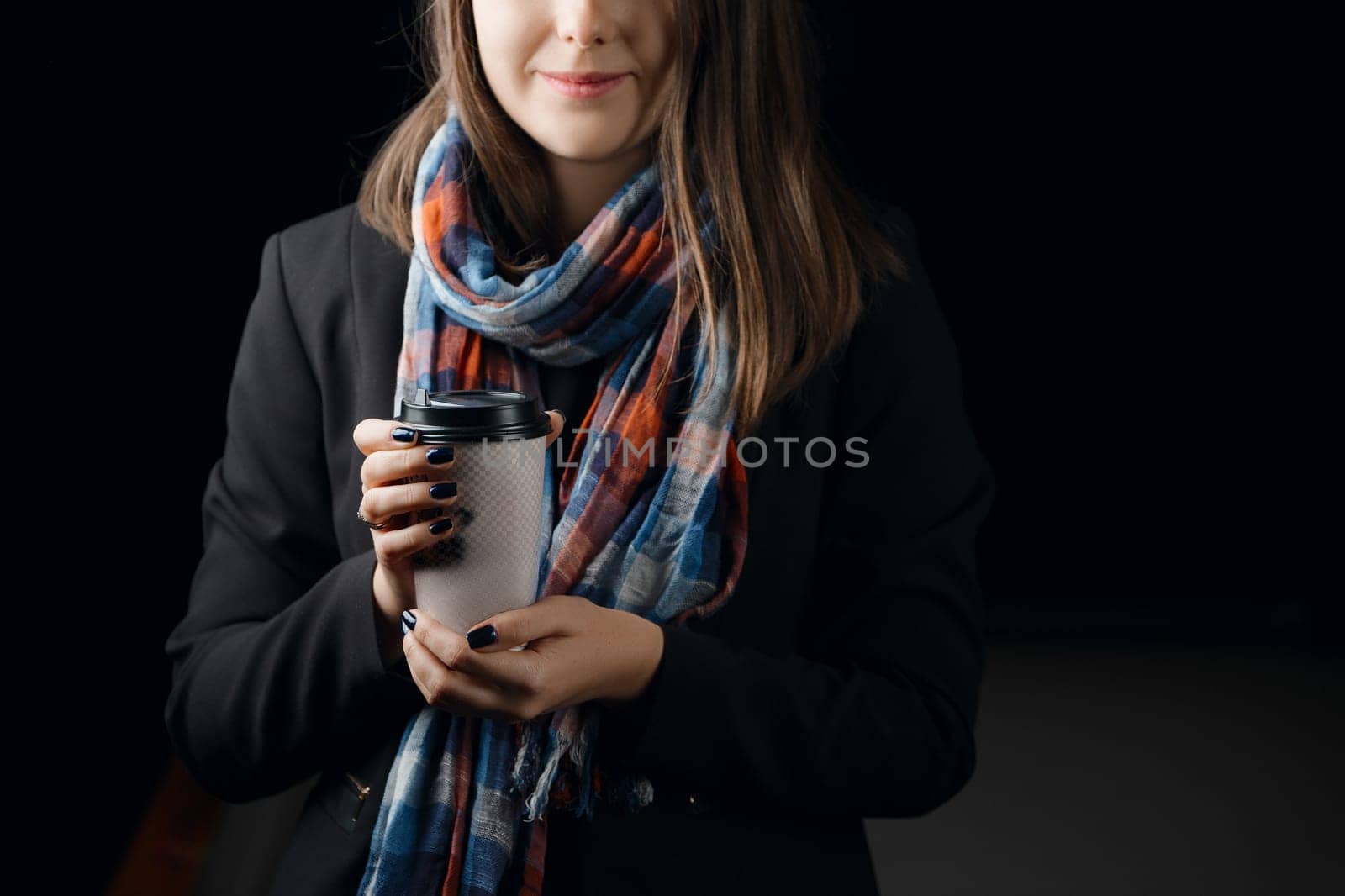 Soft focus photo of cardboard cup of coffee in female hands.