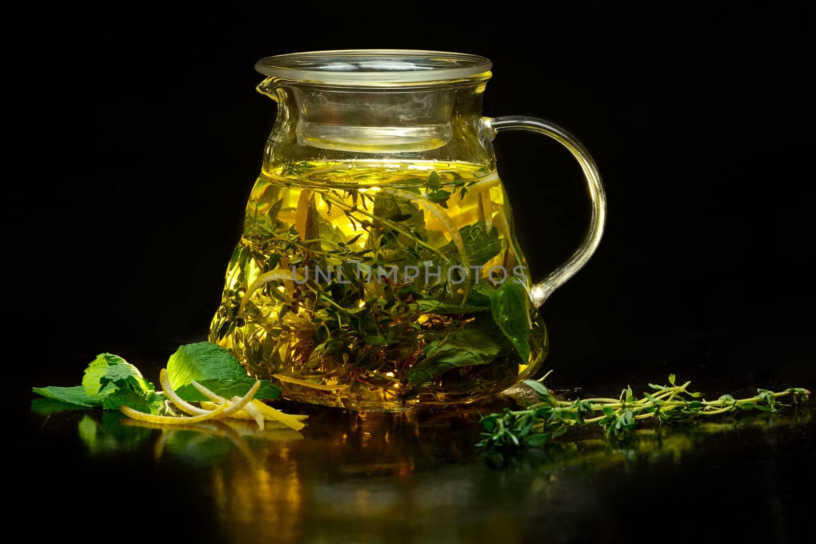 Pot with fruit tea on black background. (soft focus photo)