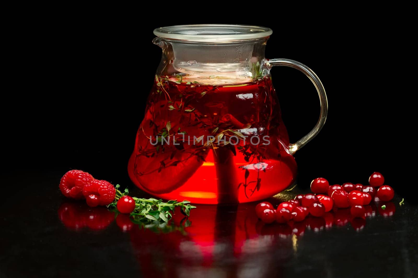 Berry tea with fresh currants, raspberries and strawberries. Teapot with fruits and berries.