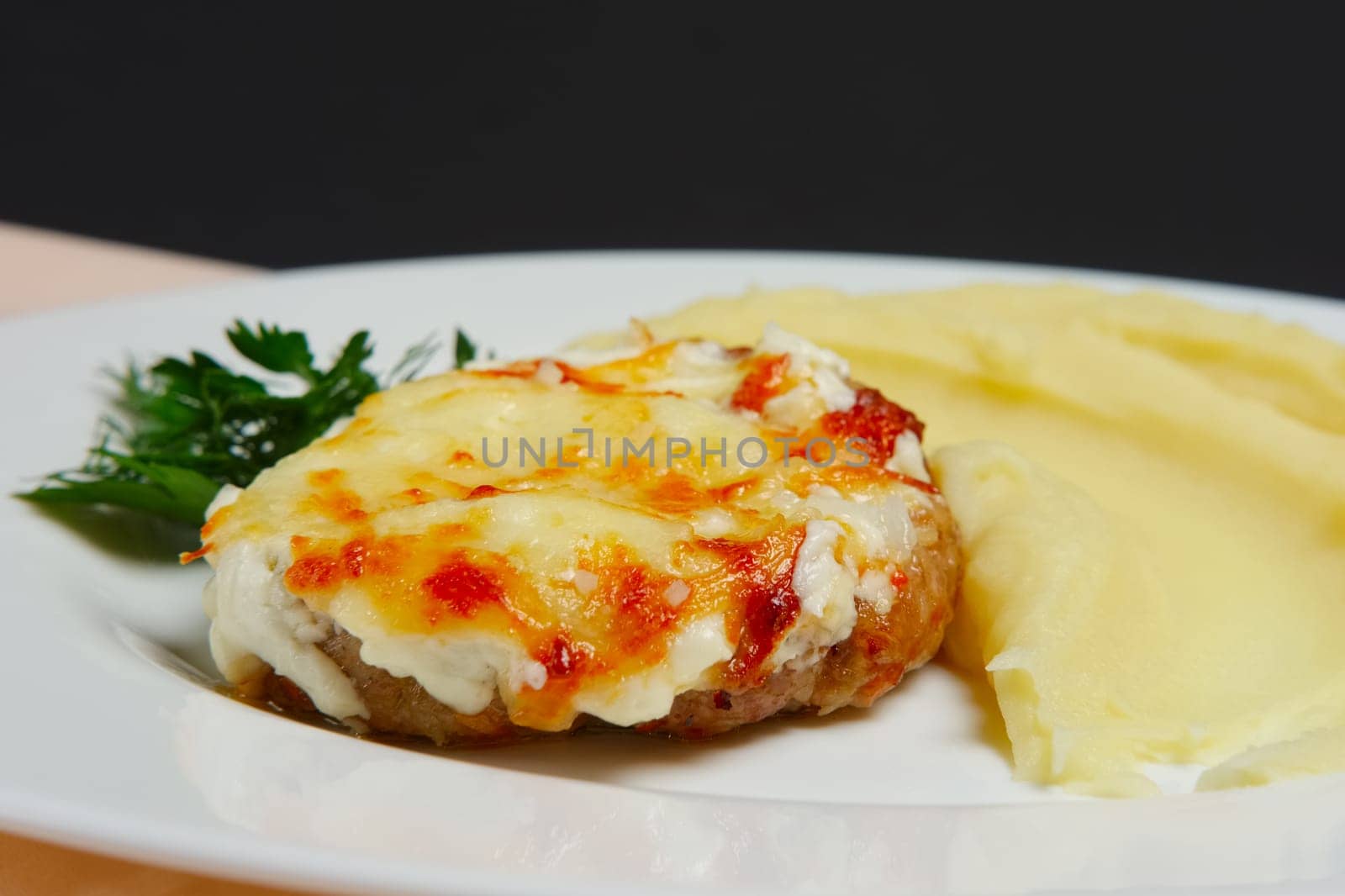 Meat cutlet with cheese and mashed potato. Closeup photo with selective focus.