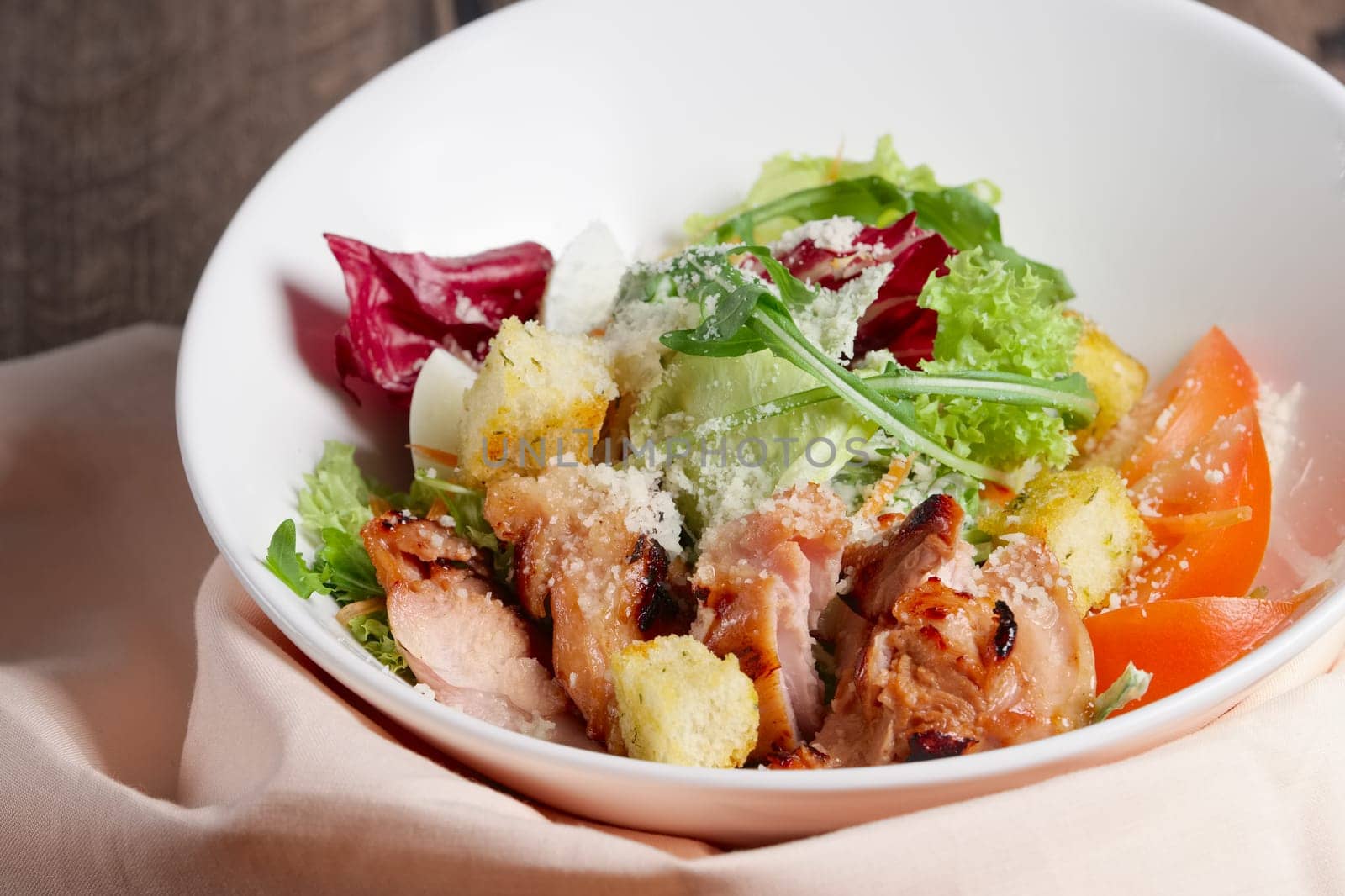 Plate with salad with meat, tomato, red and green cabbage, cheese and crouton