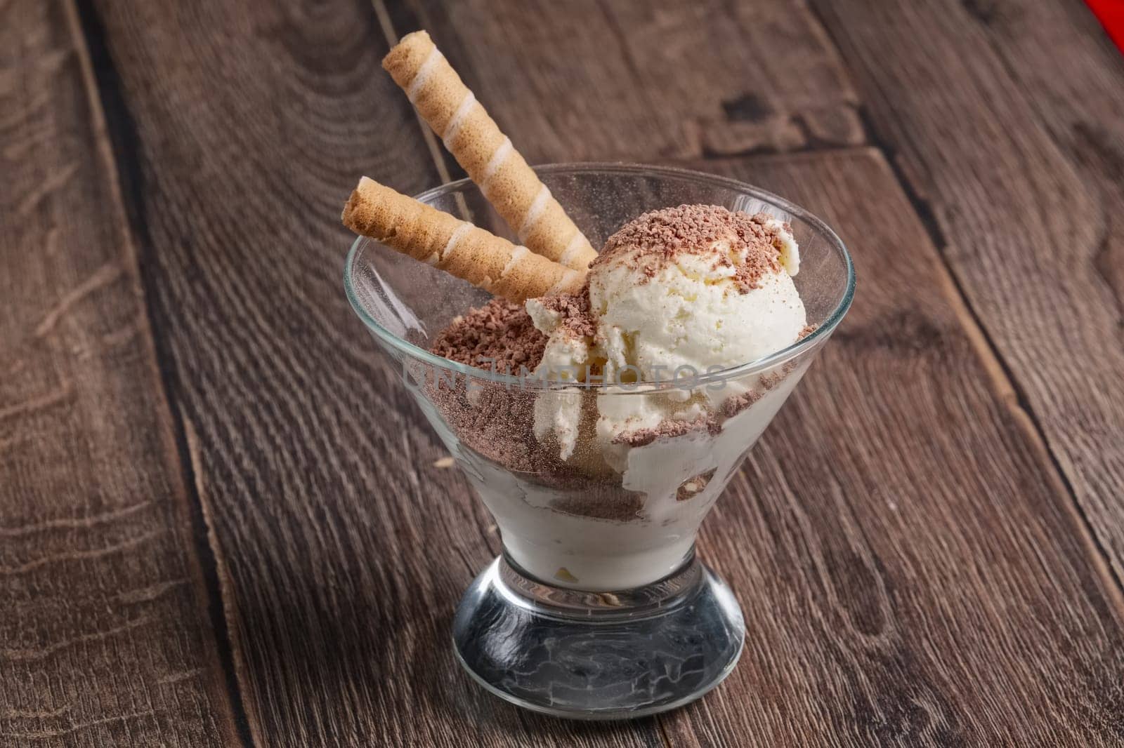 ice cream with chocolate and cookie in glass on wooden table