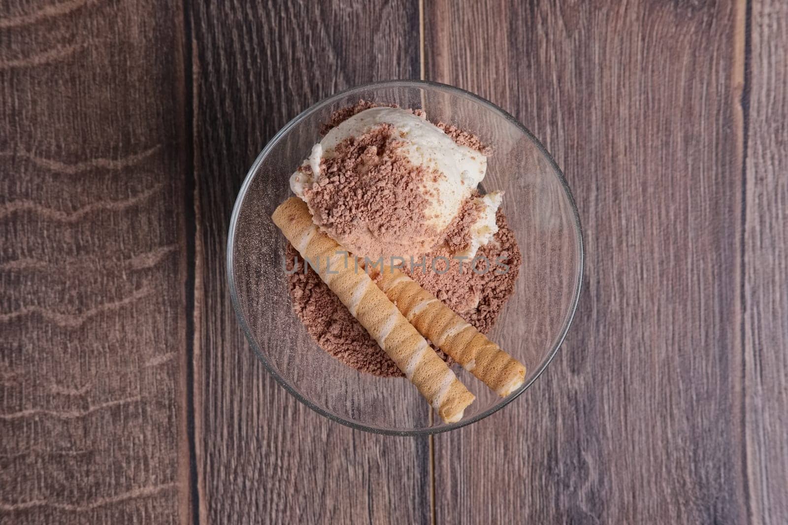 ice cream with chocolate and cookie in glass on wooden table. Top view.