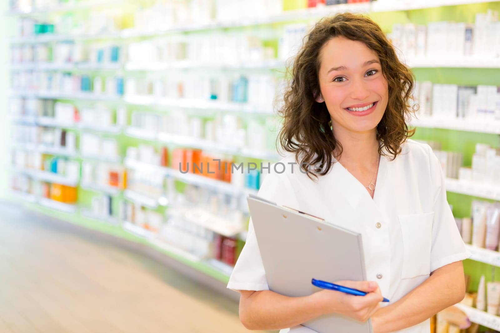 View of an Attractive pharmacist taking notes at work