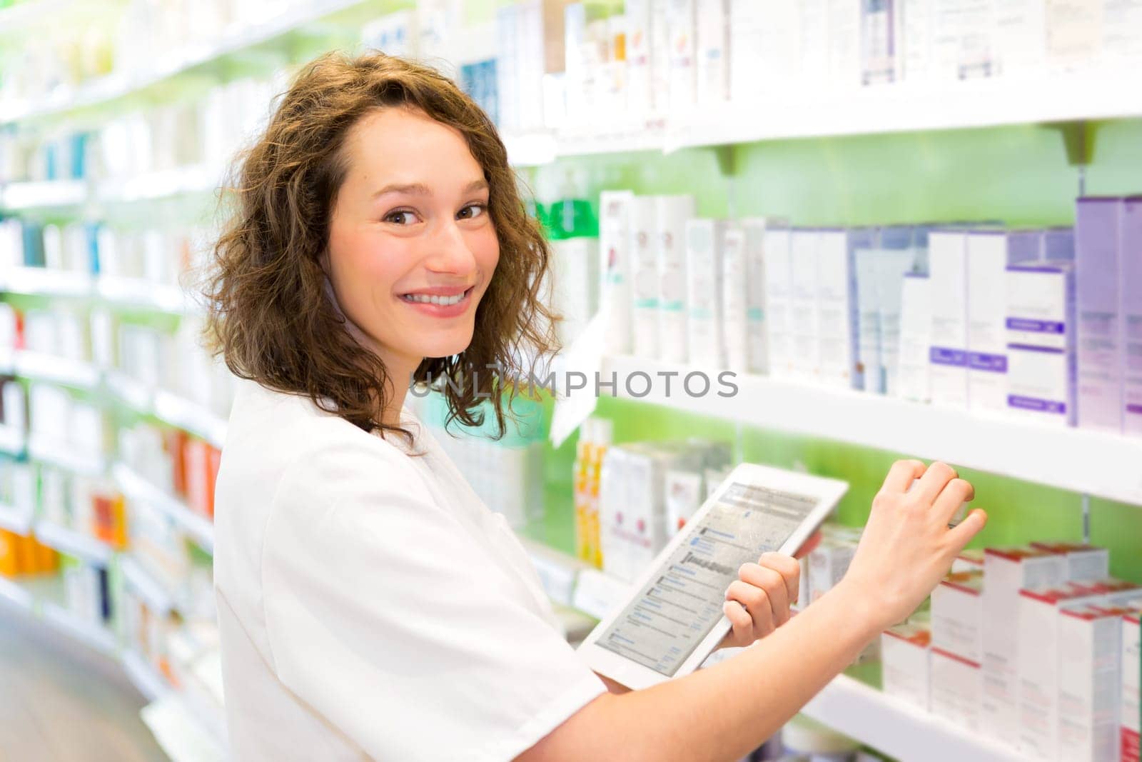 VIew of an Attractive pharmacist using tablet at work
