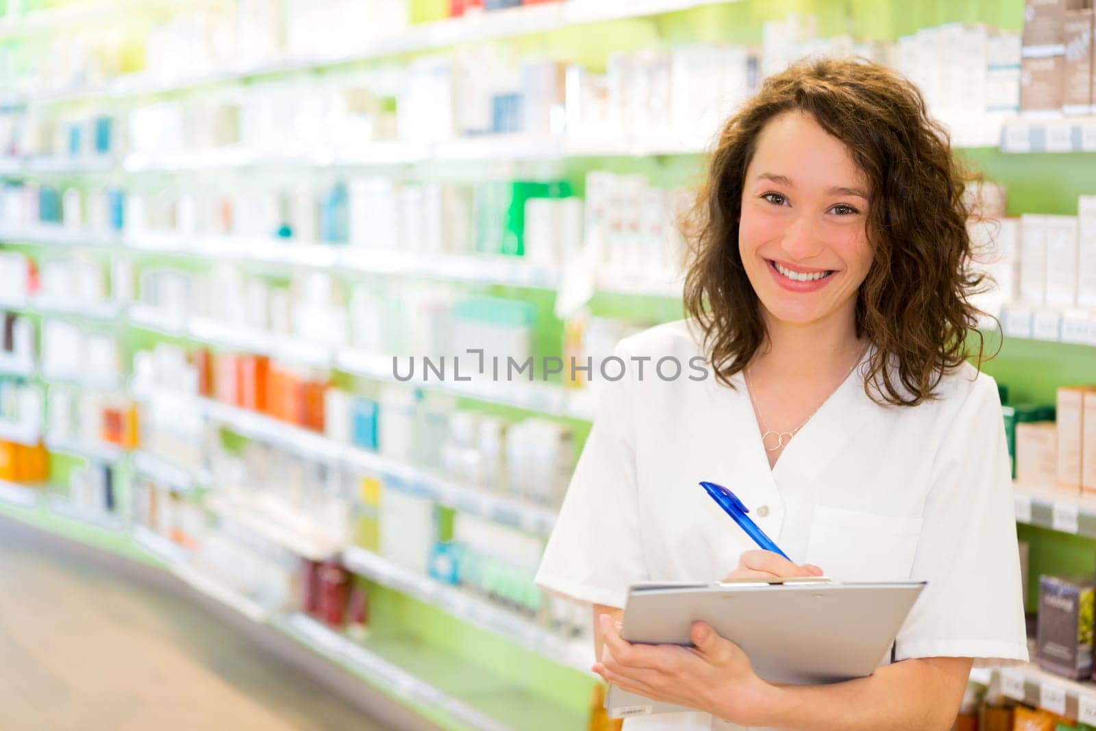 View of an Attractive pharmacist taking notes at work