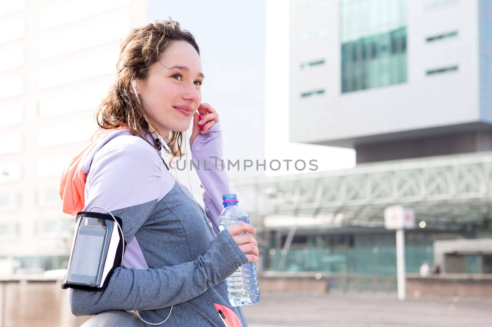 View of a Young attractive woman adjust her music player before running