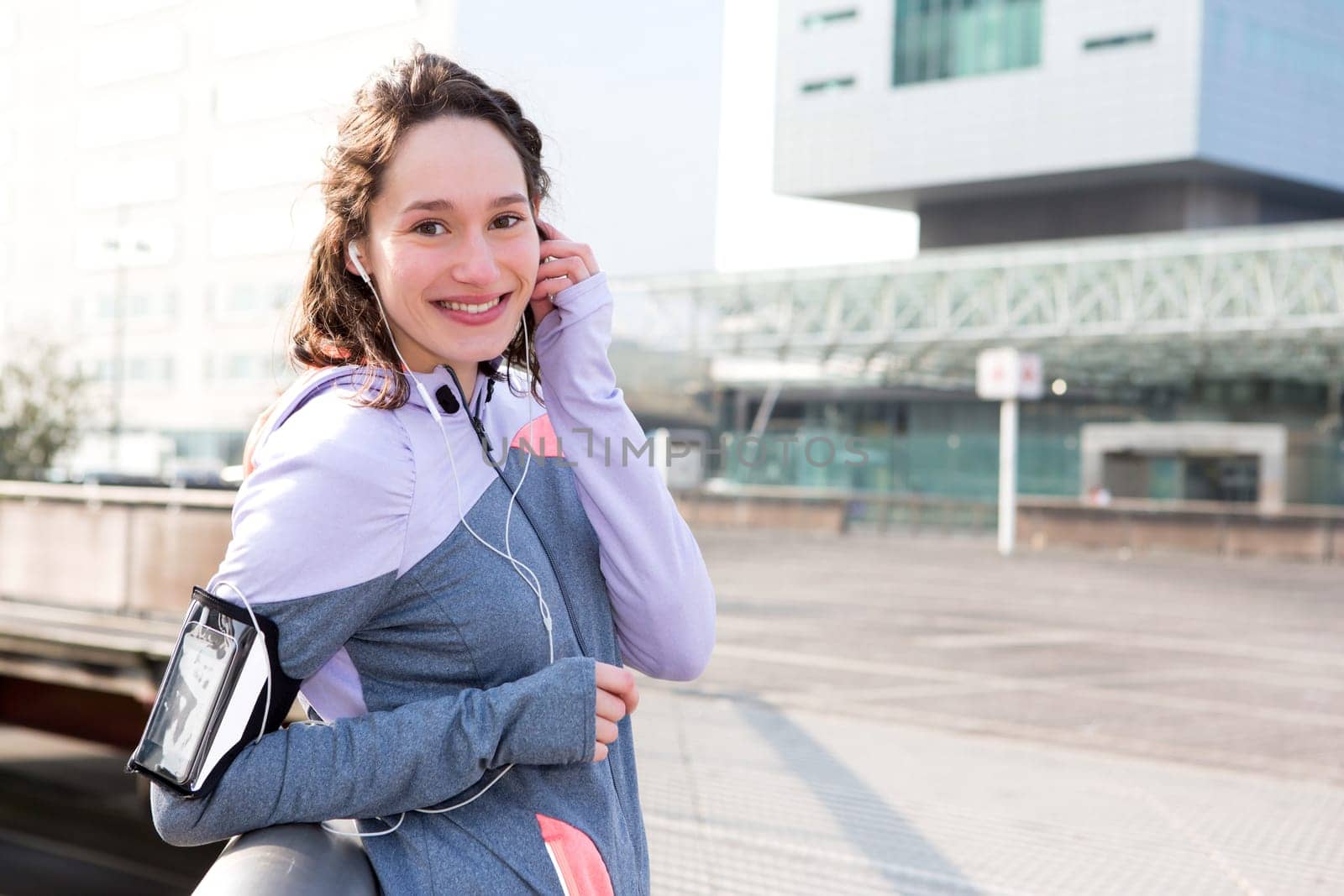 View of a Young attractive woman adjust her music player before running