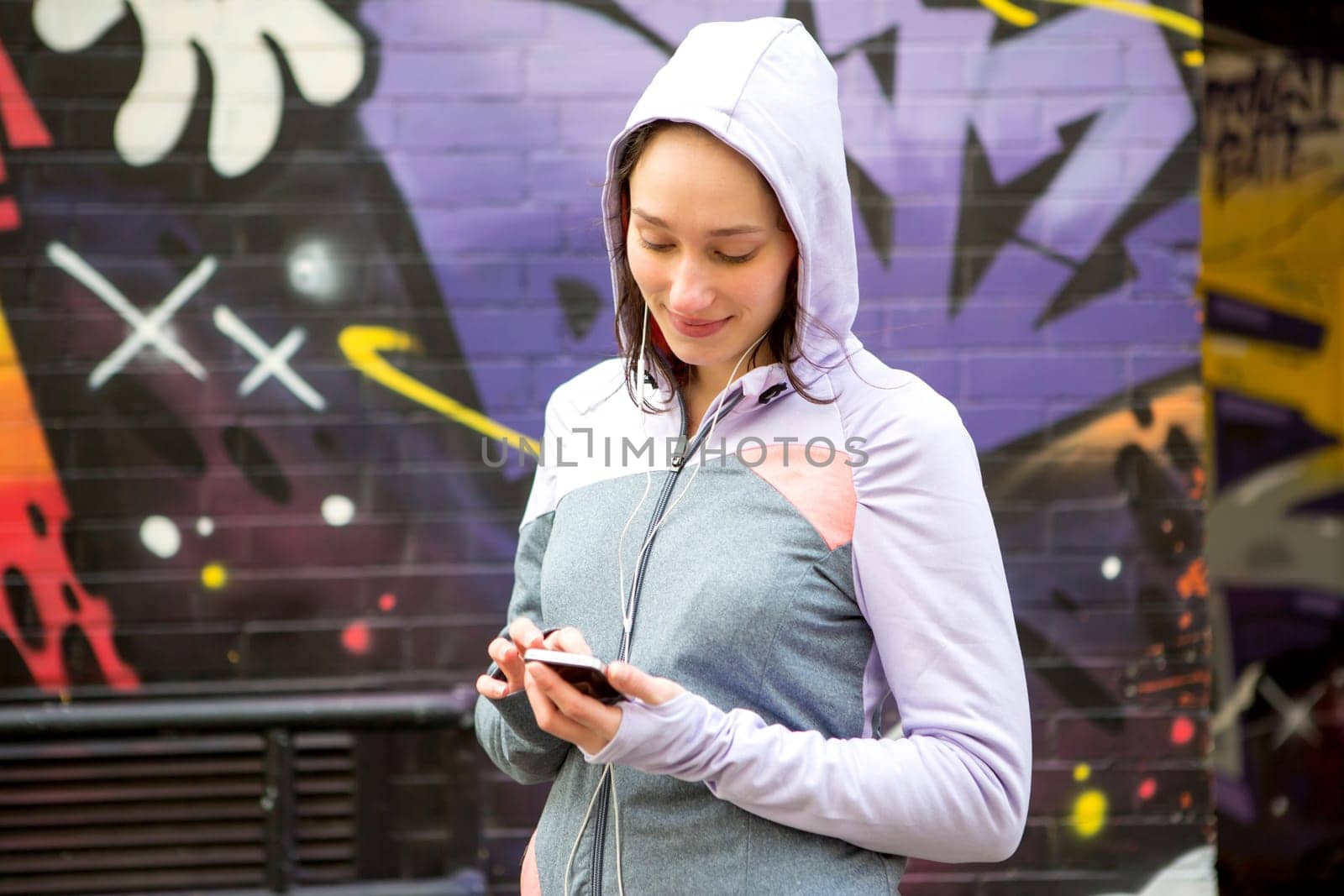 View of a Young attractive woman adjust her music player before running
