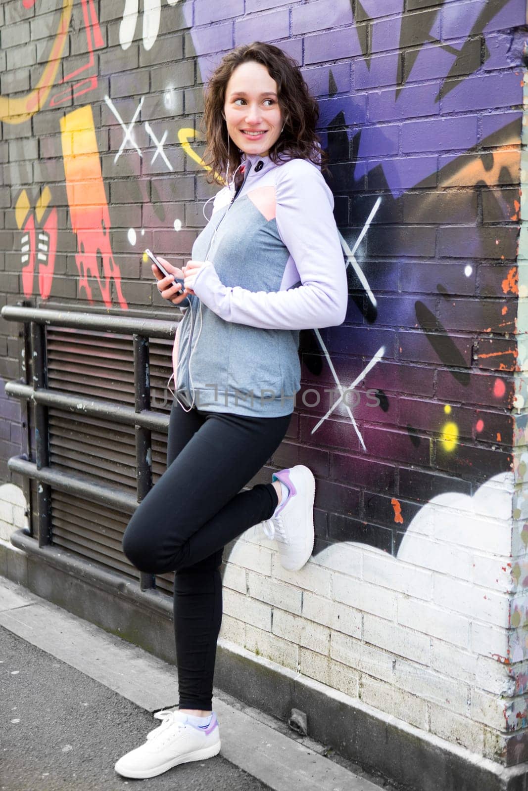 View of a Young attractive woman adjust her music player before running