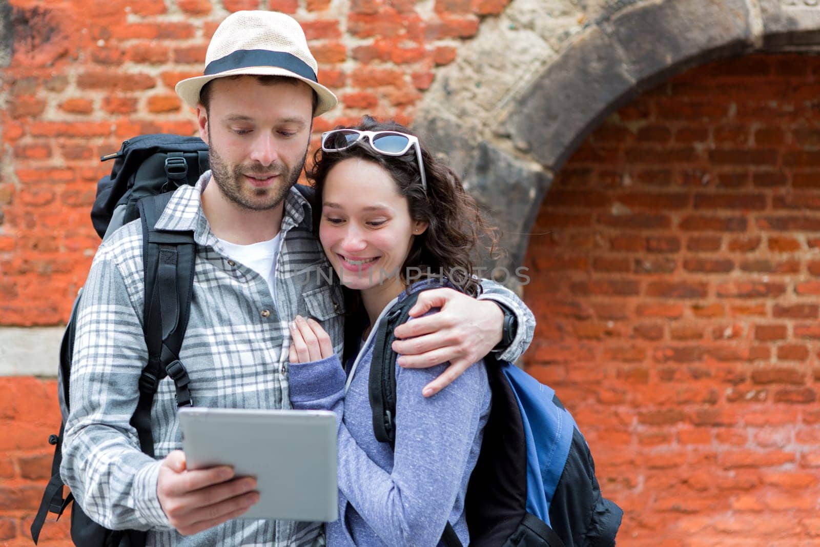 View of a Young couple of tourists using tablet to visit city
