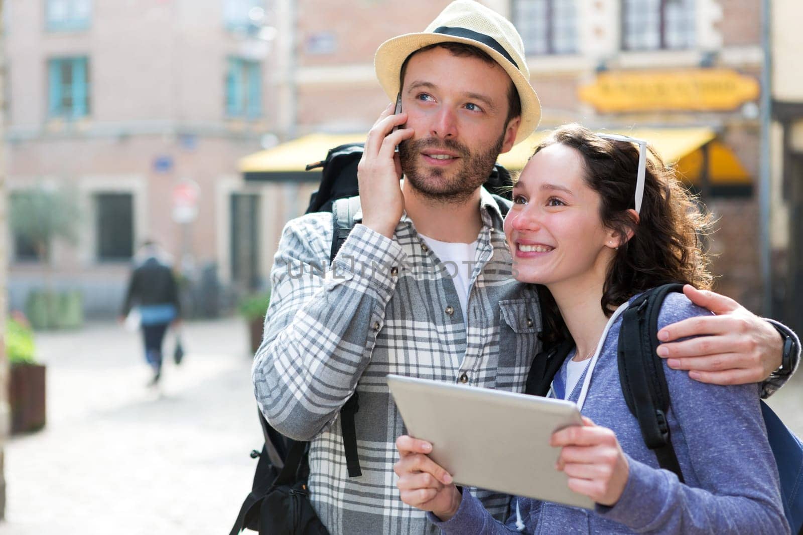 View of a Couple of attractive tourists using tablet and smartphone