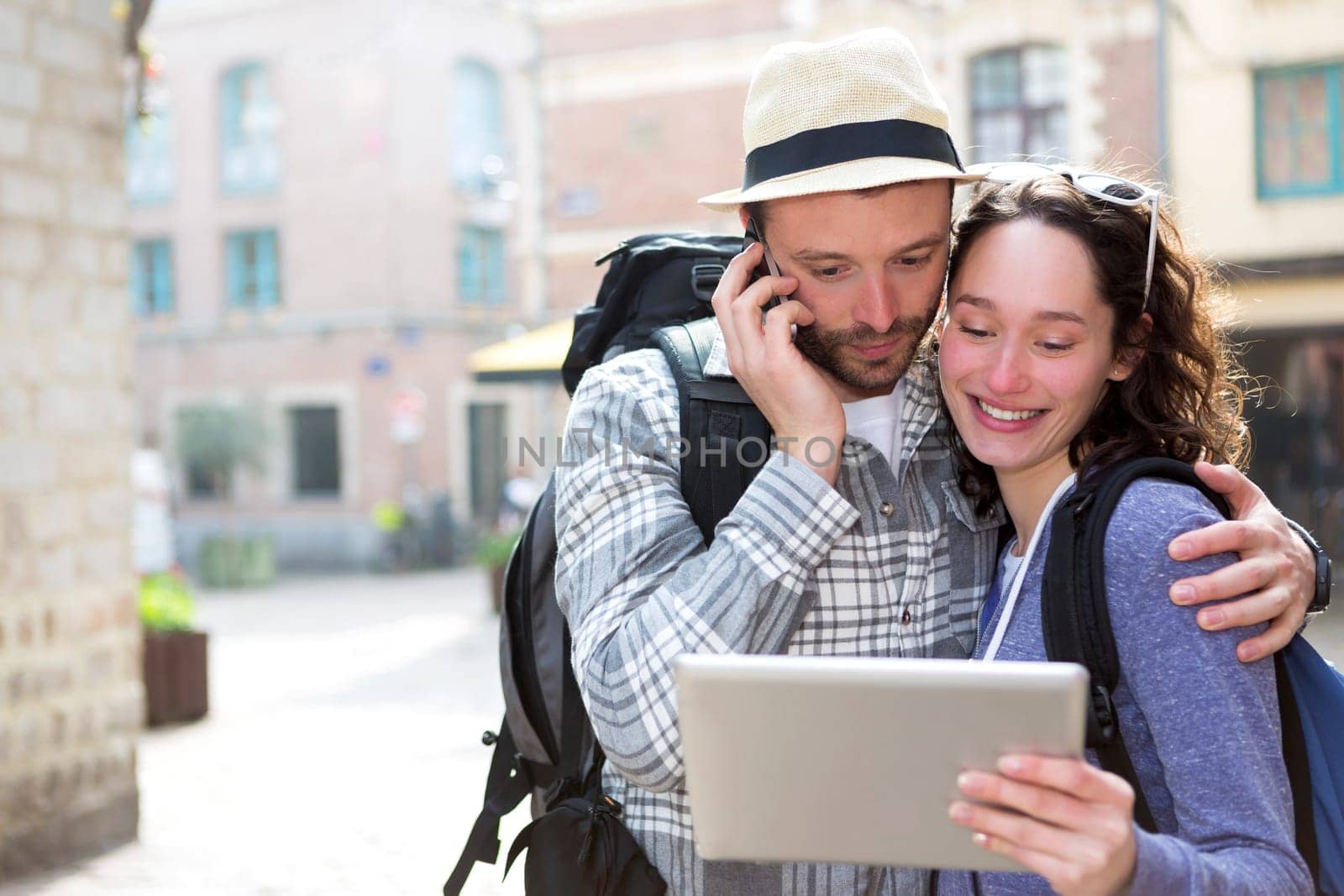 View of a Couple of attractive tourists using tablet and smartphone