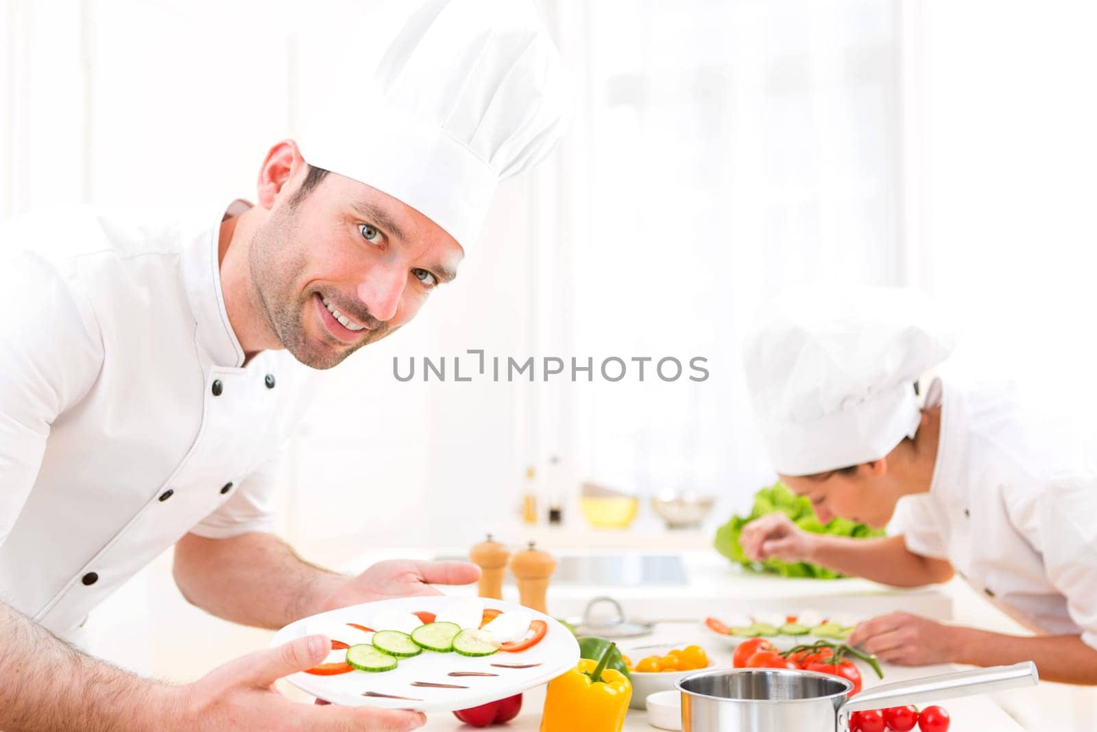 View of a Young attractive professional chef cooking in his kitchen