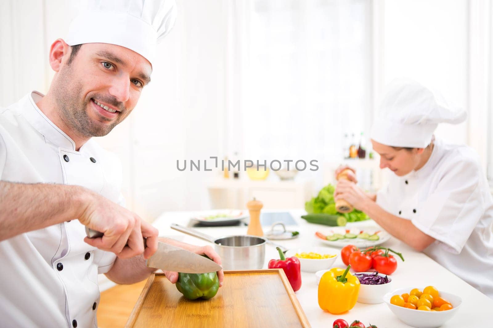 View of a Young attractive professional chef cooking in his kitchen