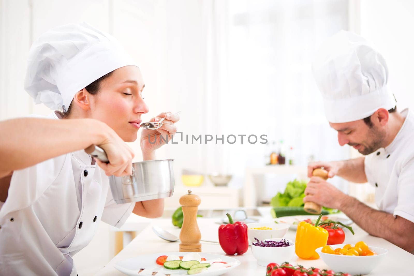 View of a Young attractive professional chef tasting sauce