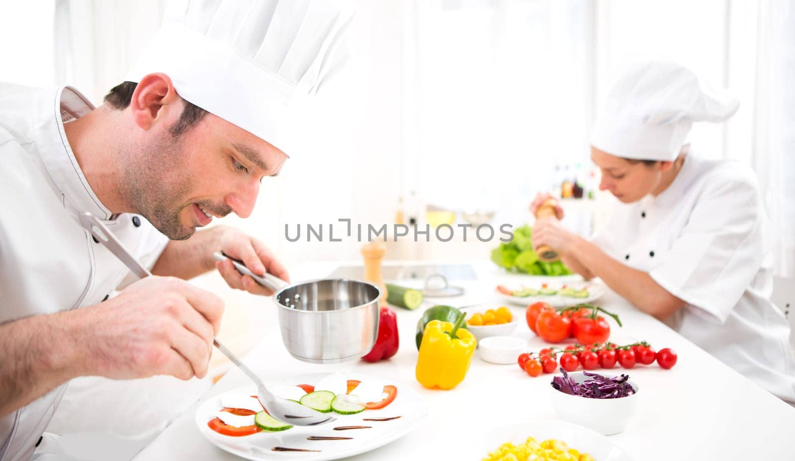 View of a Young attractive professional chef cooking in his kitchen