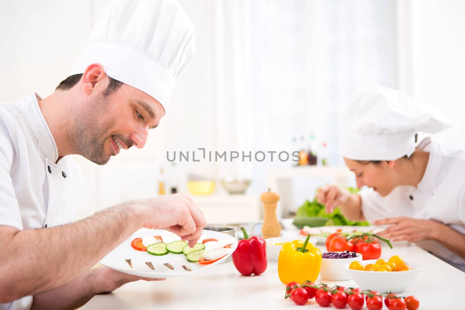 View of a Young attractive professional chef cooking in his kitchen
