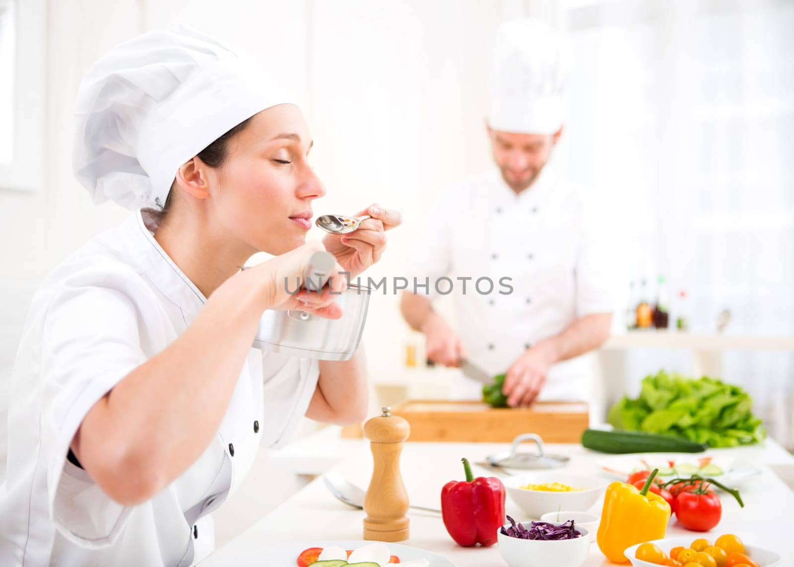 View of a Young attractive professional chef tasting sauce