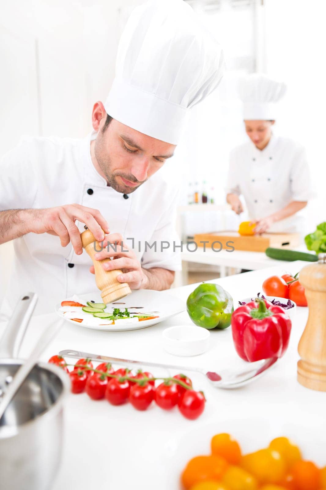 View of a Young attractive professional chef cooking in his kitchen