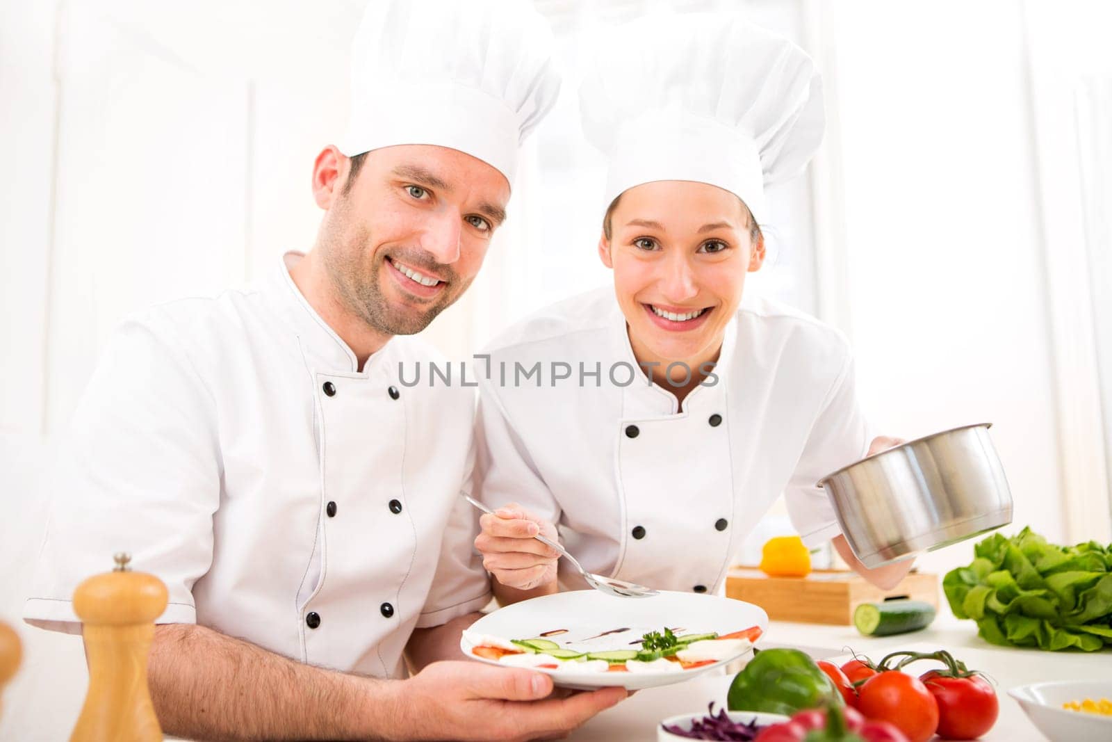 View of Young attractives professionals chefs cooking together