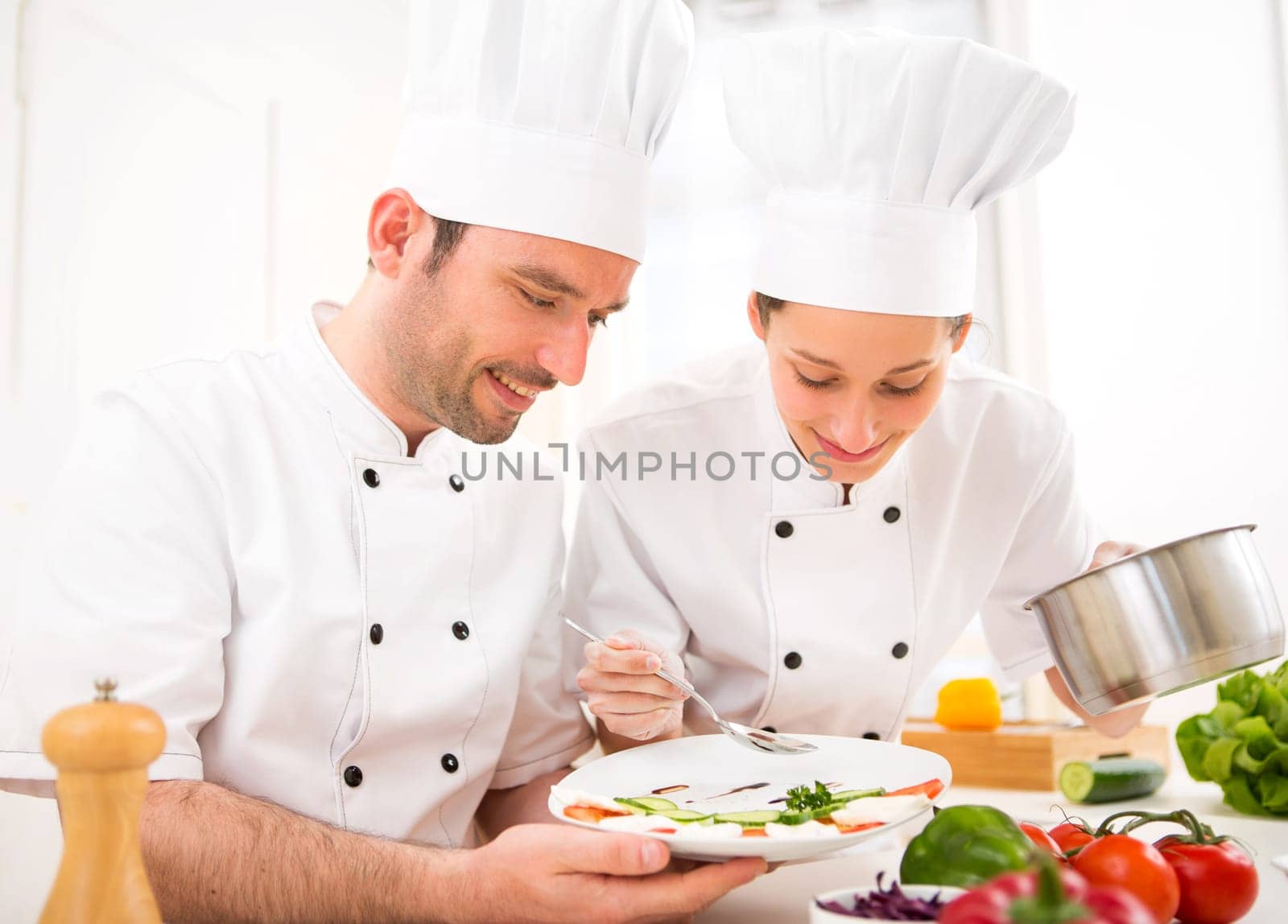 View of Young attractives professionals chefs cooking together