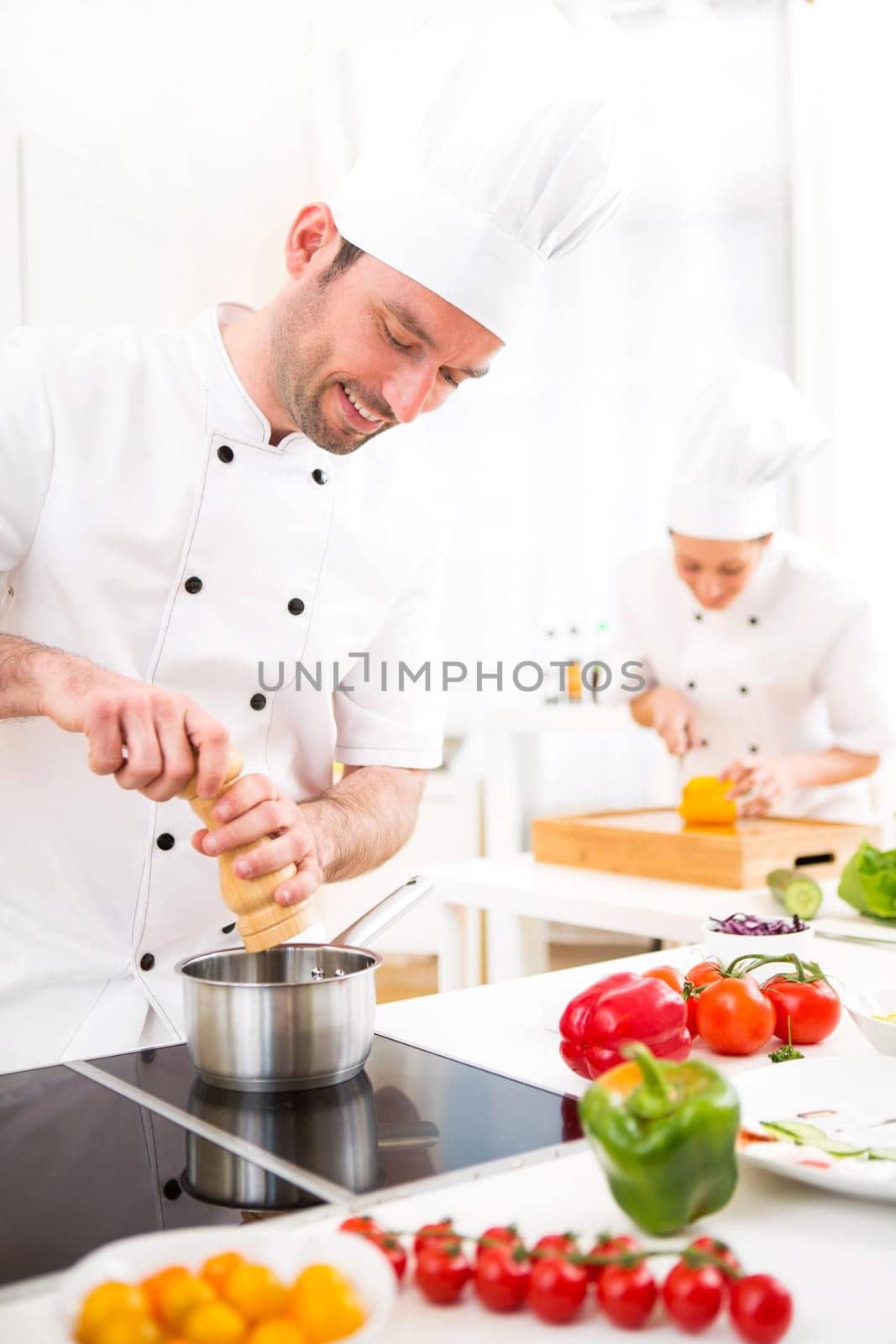 View of a Young attractive professional chef cooking in his kitchen