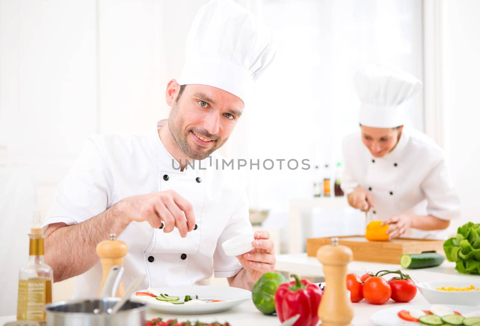 View of a Young attractive professional chef cooking in his kitchen