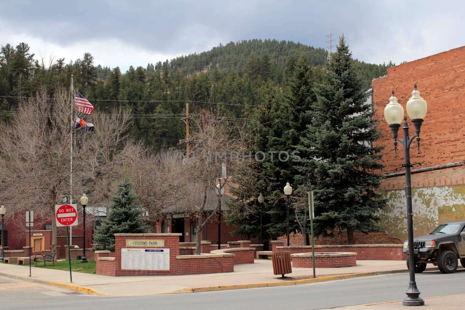 Idaho Springs, CO, USA - April 21, 2014: Citizens Park in downtown on Miner Street in springtime during the day. A small park in a small town with a historical marker about how and why the park was built.