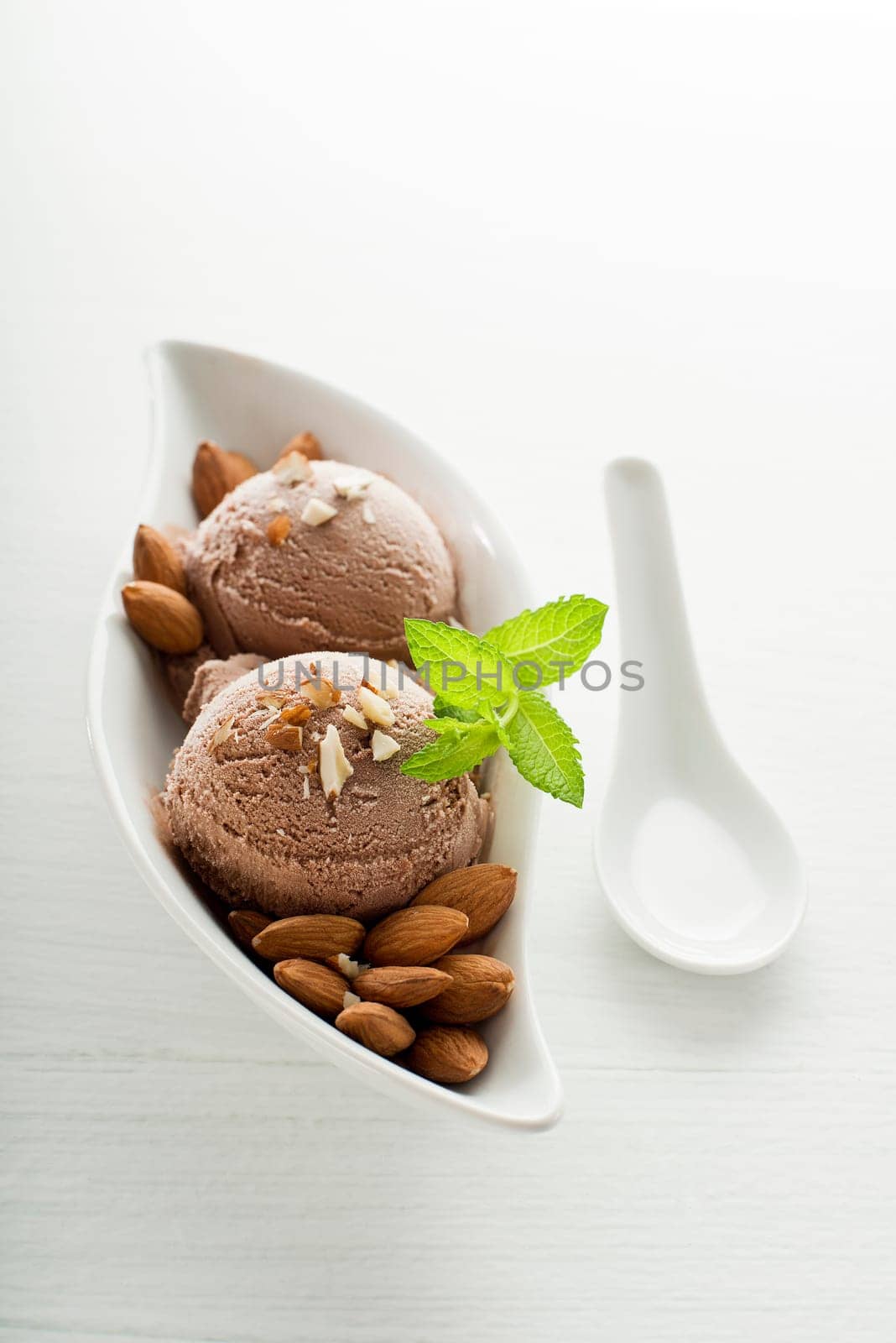 Fresh almond ice cream on white plate close up