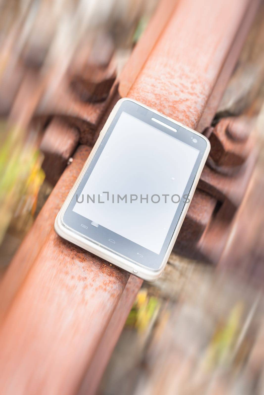 Travel on the tracks of the technology. Smartphone on rail like a metaphor.