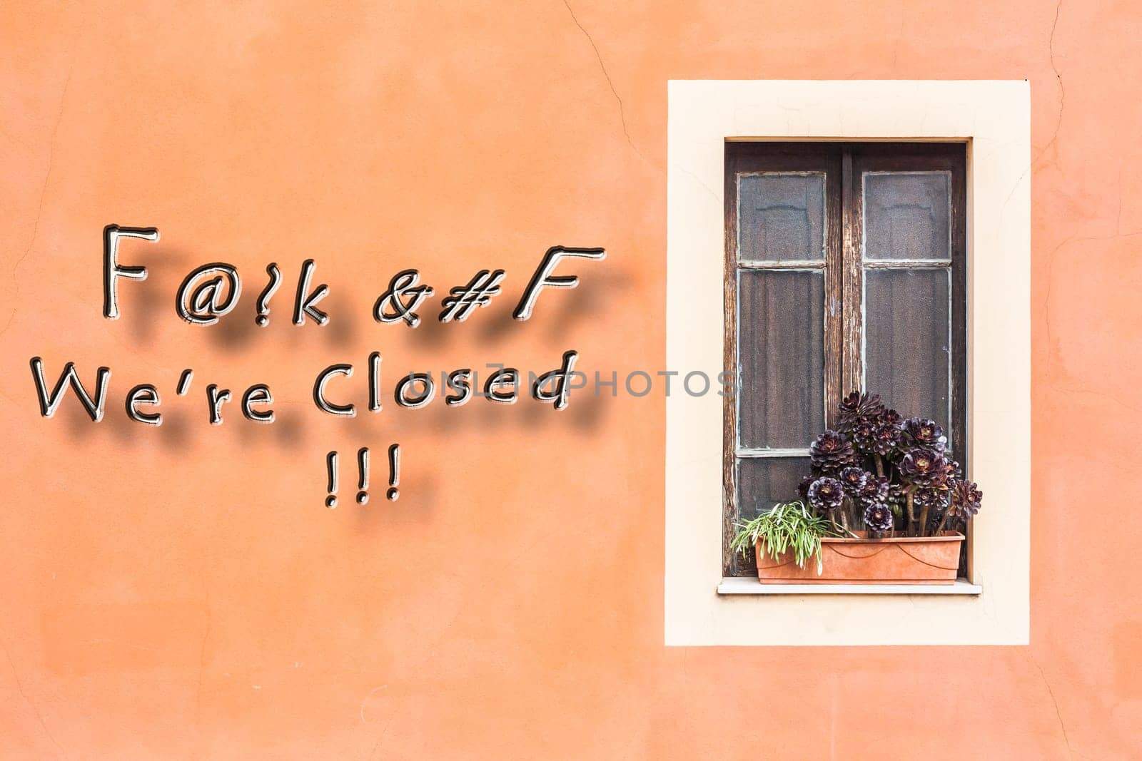 Closed window with planter  and orange wall with written.