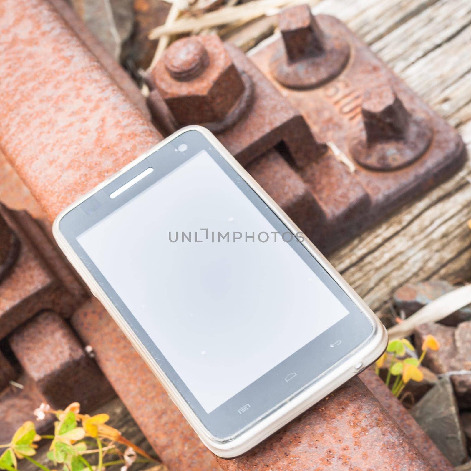 Travel on the tracks of the technology. Smartphone on rail like a metaphor.